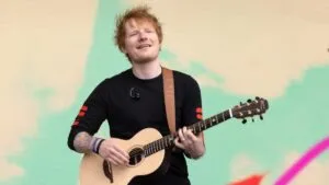 Ed Sheeran en escenario iluminado con público vibrante en Hard Rock Live Miami, reflejando la importancia cultural y económica del espectáculo musical