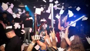 Multitud en un club nocturno de Miami disfruta las Napkin Wars, con servilletas blancas volando y ambiente festivo que impulsa turismo y cultura local.