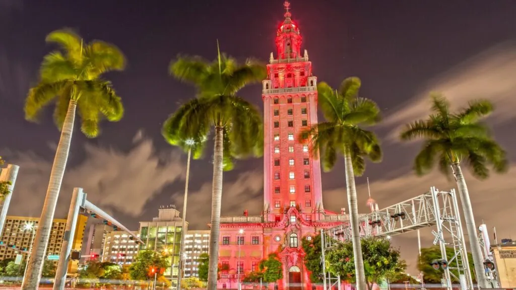 Torre de la Libertad iluminada en Miami durante su centenario, destacando su importancia cultural y turística como emblema histórico de la ciudad.