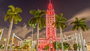 Torre de la Libertad iluminada en Miami durante su centenario, destacando su importancia cultural y turística como emblema histórico de la ciudad.