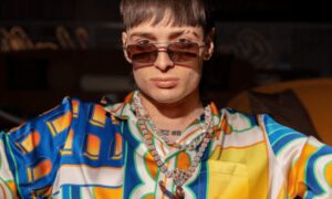 Peso Pluma en escenario recibiendo el Premio Billboard Vanguardia en Miami con ambiente cultural y económico latino.