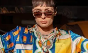 Peso Pluma en escenario recibiendo el Premio Billboard Vanguardia en Miami con ambiente cultural y económico latino.