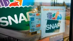 Mujer revisa su tarjeta EBT en un supermercado de Miami mientras el cierre del gobierno amenaza la entrega de beneficios SNAP.