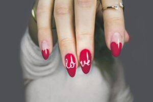 Uñas decoradas con piedras y metal brillando bajo luz de clínica médica en Miami
