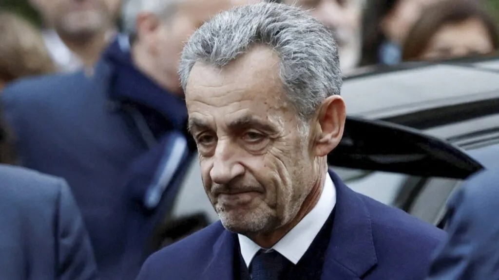El expresidente Nicolas Sarkozy escoltado por agentes policiales al ingresar a la prisión de La Santé en París.