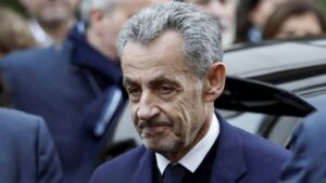 El expresidente Nicolas Sarkozy escoltado por agentes policiales al ingresar a la prisión de La Santé en París.