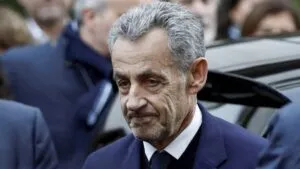 El expresidente Nicolas Sarkozy escoltado por agentes policiales al ingresar a la prisión de La Santé en París.