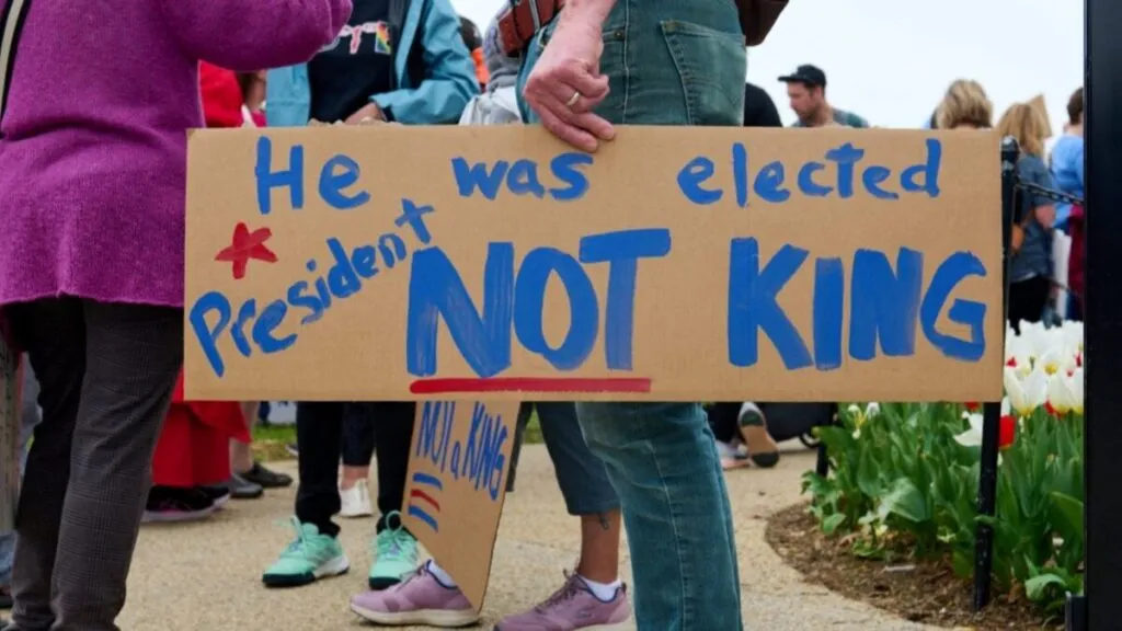 Manifestantes marchan pacíficamente por las calles de Miami durante las protestas No Kings, con pancartas y banderas por la igualdad.