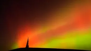 Cielo de Miami iluminado por una aurora boreal roja y verde durante una tormenta geomagnética.