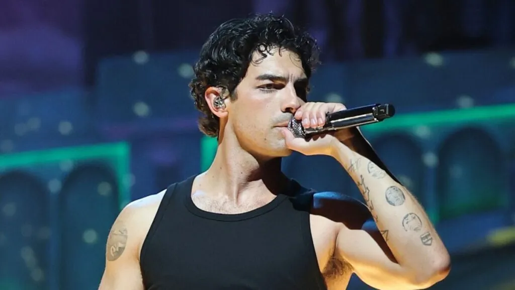 Joe Jonas caminando por un vecindario de Miami, rodeado de restaurantes locales y cafés que forman parte de su rutina diaria en la ciudad.