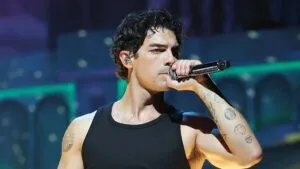 Joe Jonas caminando por un vecindario de Miami, rodeado de restaurantes locales y cafés que forman parte de su rutina diaria en la ciudad.