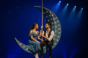 Escena teatral del musical Julieta con montaje vibrante y escenografía en forma de luna sobre escenario iluminado