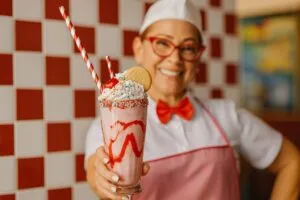 Exterior de un diner cubano moderno en Miami, con banderas cubanas y clientes locales en un ambiente vibrante