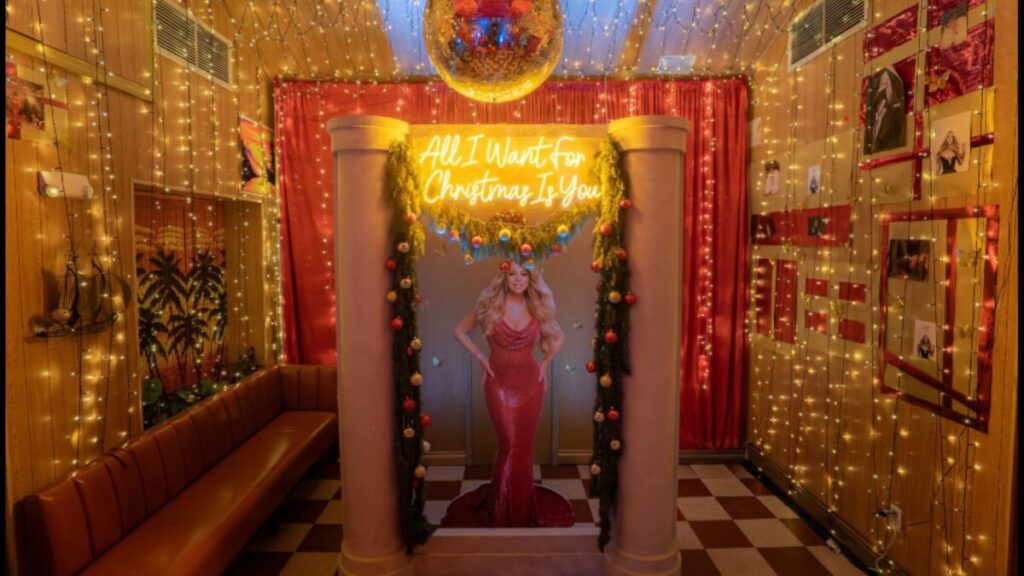 Ambiente navideño inspirado en Mariah Carey con decoración temática, luces cálidas y elementos festivos en un bar de Miami Beach