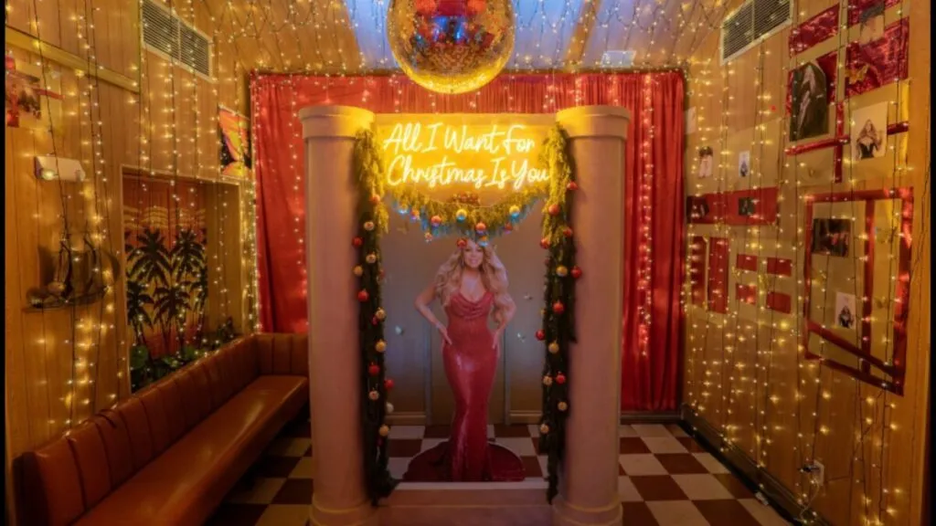 Ambiente navideño inspirado en Mariah Carey con decoración temática, luces cálidas y elementos festivos en un bar de Miami Beach