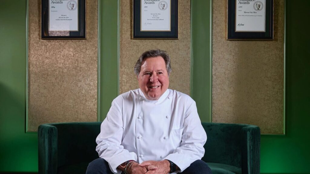 Retrato editorial de Norman Van Aken en cocina moderna con elementos que evocan sabores locales y cultura culinaria de Miami