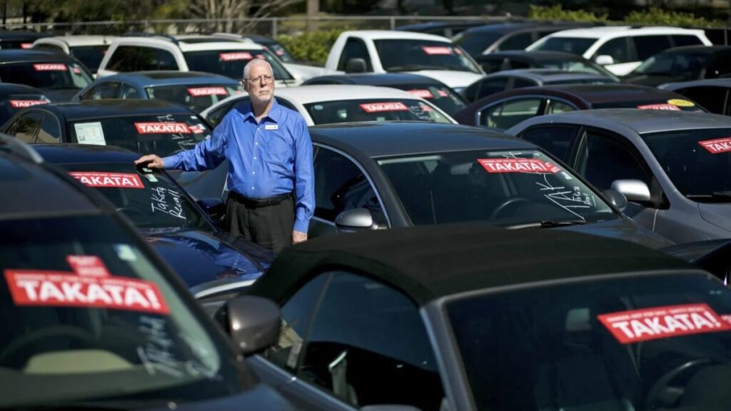 Deuda automotriz en Miami con autos estacionados y señales de presión financiera