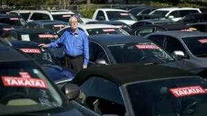 Deuda automotriz en Miami con autos estacionados y señales de presión financiera