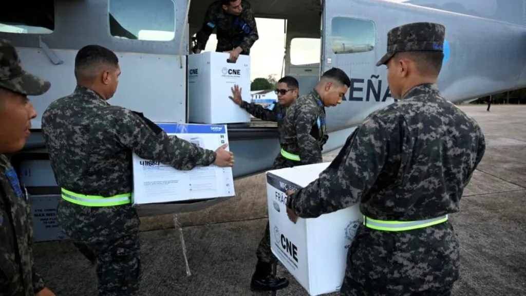 Escena urbana durante elecciones de Honduras con ciudadanos participando en un clima de tensión política.