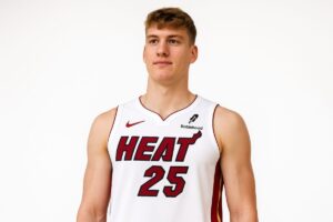 Kasparas Jakucionis en uniforme de Miami Heat, sobre fondo blanco, en sesión editorial profesional