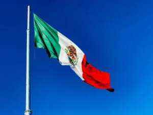 Bandera de México ondeando en ceremonia cívica que refuerza la identidad nacional y la unión social