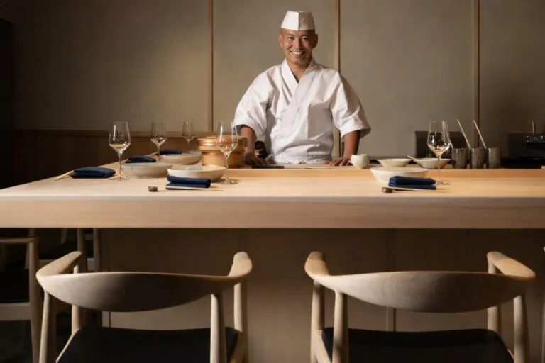 Chef japonés en mostrador de madera hinoki sirviendo sushi en restaurante de lujo en el Design District de Miami