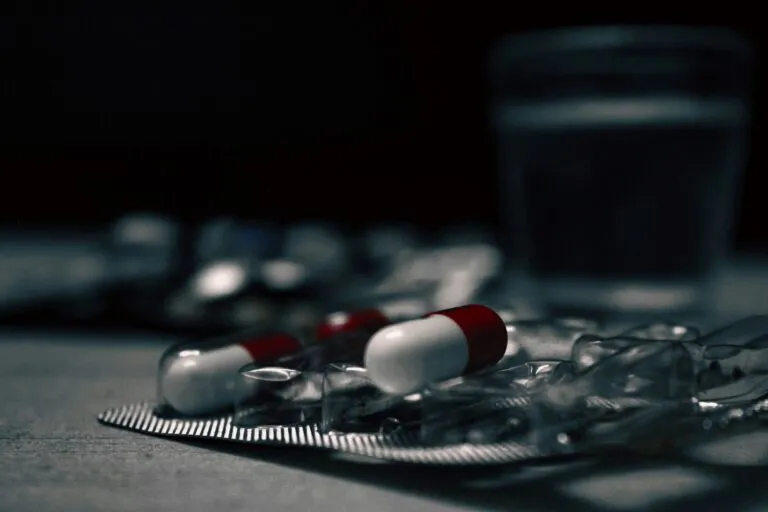 Personas hispanas y afroamericanas discutiendo salud comunitaria tras cambios en el programa ADAP de Florida que limita acceso a medicamentos para VIH.