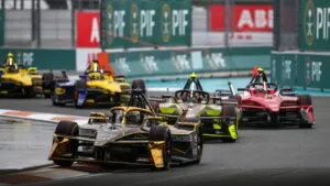 Fórmula E Miami con monoplazas eléctricos compitiendo bajo lluvia en el Hard Rock Stadium durante el ePrix ganado por Mitch Evans