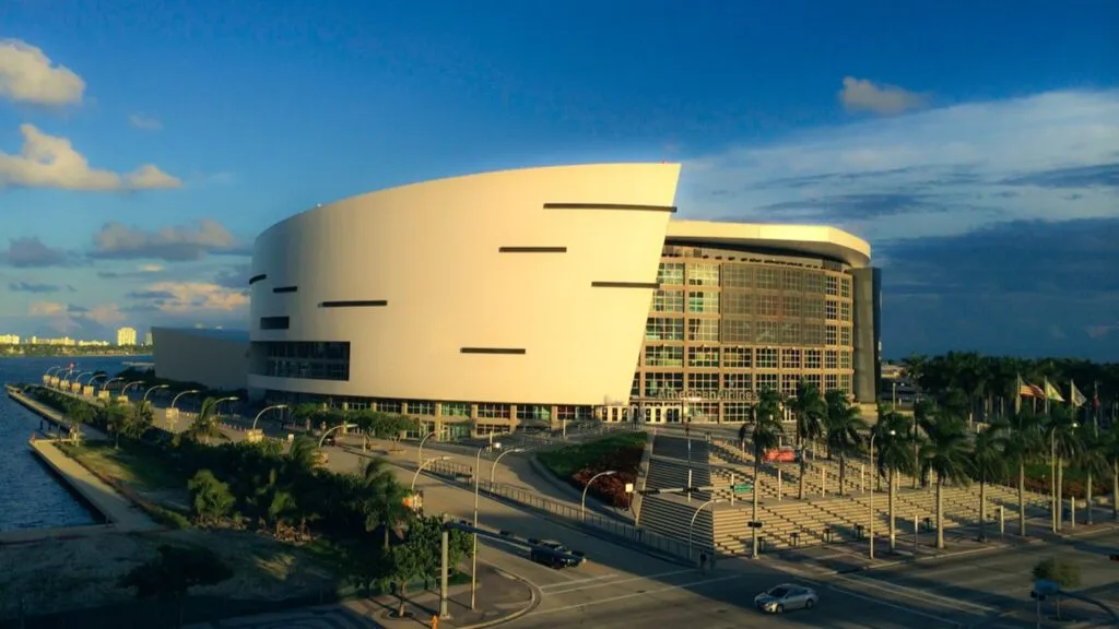 Vista exterior del Kaseya Center en Miami iluminado durante un evento nocturno junto a la bahía