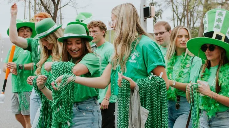 personas celebrando el Día de San Patricio con cerveza verde y decoración irlandesa en un bar de Miami