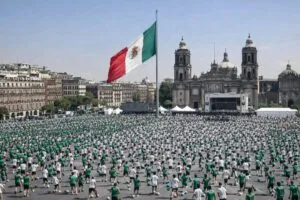 Multitud de participantes en la clase de fútbol más grande del mundo en el Zócalo de la Ciudad de México estableciendo récord Guinness.