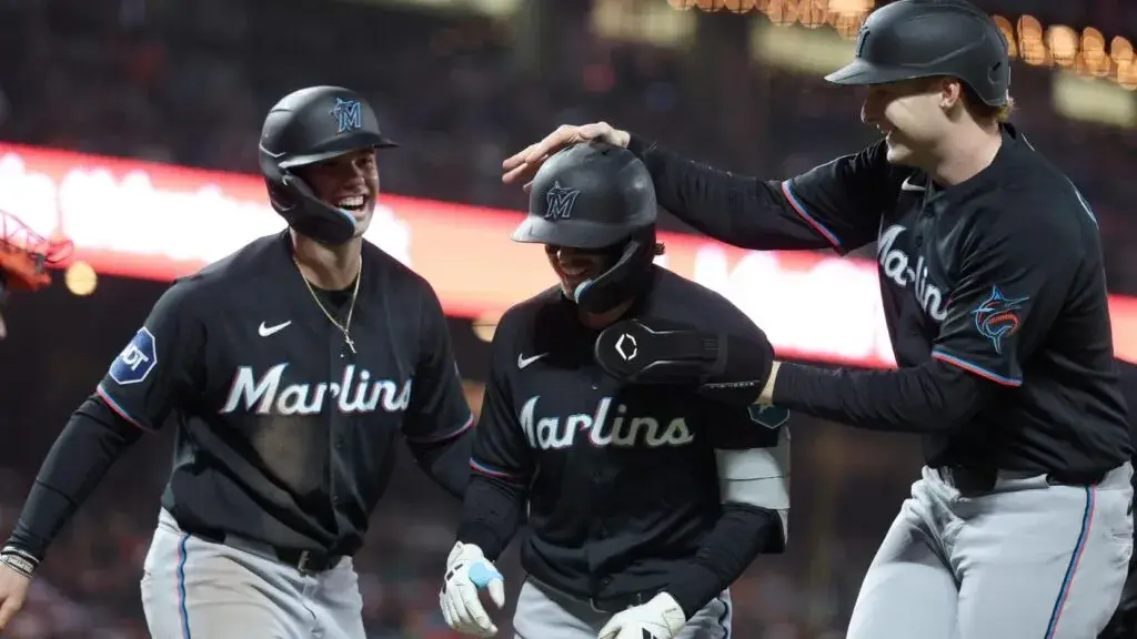 Marlins celebrando victoria con jugadores en acción durante juego de béisbol