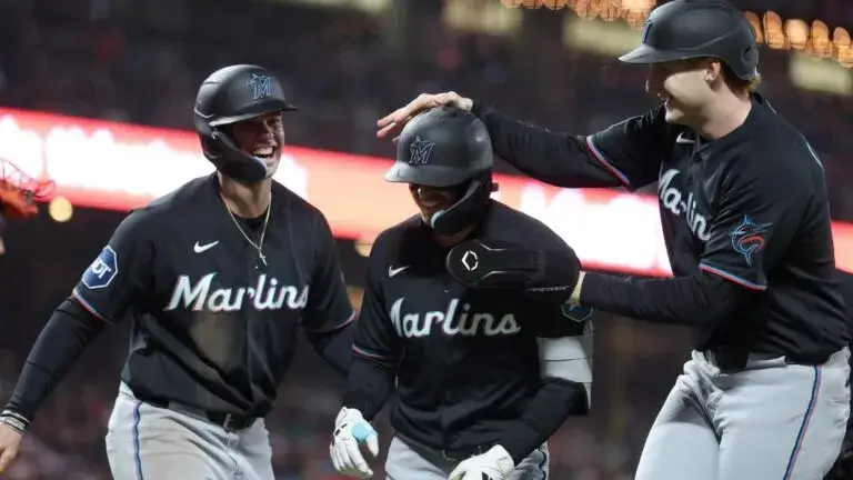 Marlins celebrando victoria con jugadores en acción durante juego de béisbol