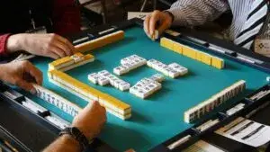 Mahjong como actividad social en grupos que se reúnen para jugar y aprender en la ciudad