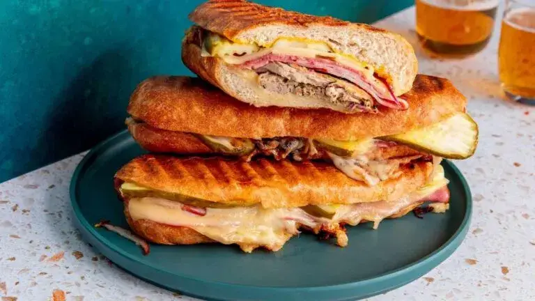 Sándwich cubano tradicional servido en restaurante histórico de Miami con pan prensado y cerdo asado