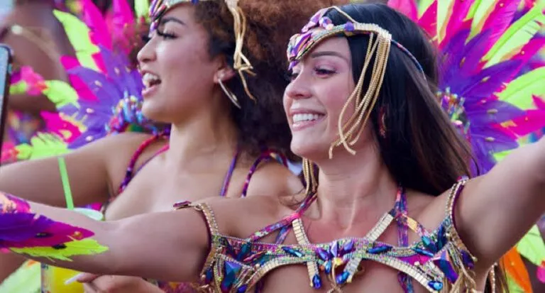 Mujeres participan en el Miami Carnival con coloridos disfraces durante una celebración de la cultura caribeña en Florida.