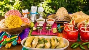 Mesa preparada para una noche mexicana con comida, música y decoración del 15 de septiembre.