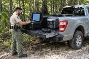 Agente de la FWC junto a un vehículo oficial durante una operación relacionada con registros privados y activistas ambientales de Florida.