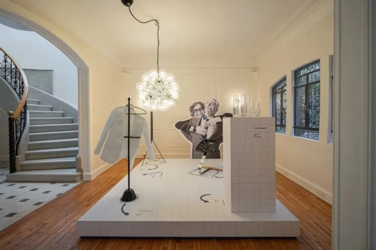 Exposición de diseño italiano dedicada a Achille Castiglioni con muebles, luminarias, fotografías y documentos históricos.