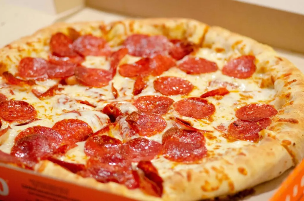 Pizza preparada para comida a domicilio junto con antojitos mexicanos y aplicaciones de entrega digital.